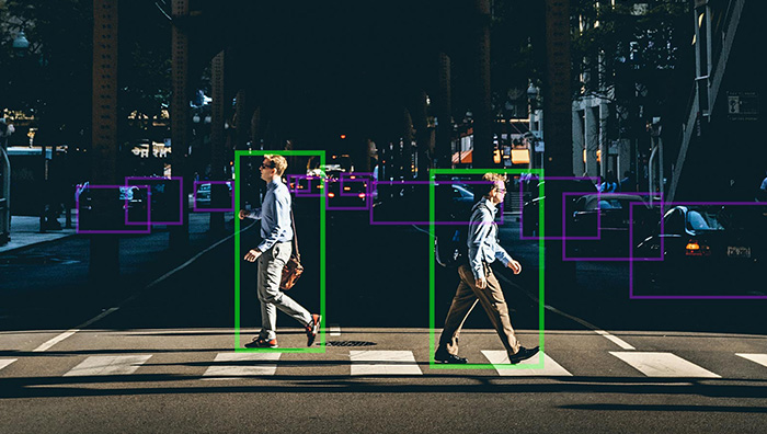Two people on the crossroads in bounding boxes, illustrating aiWare's safety